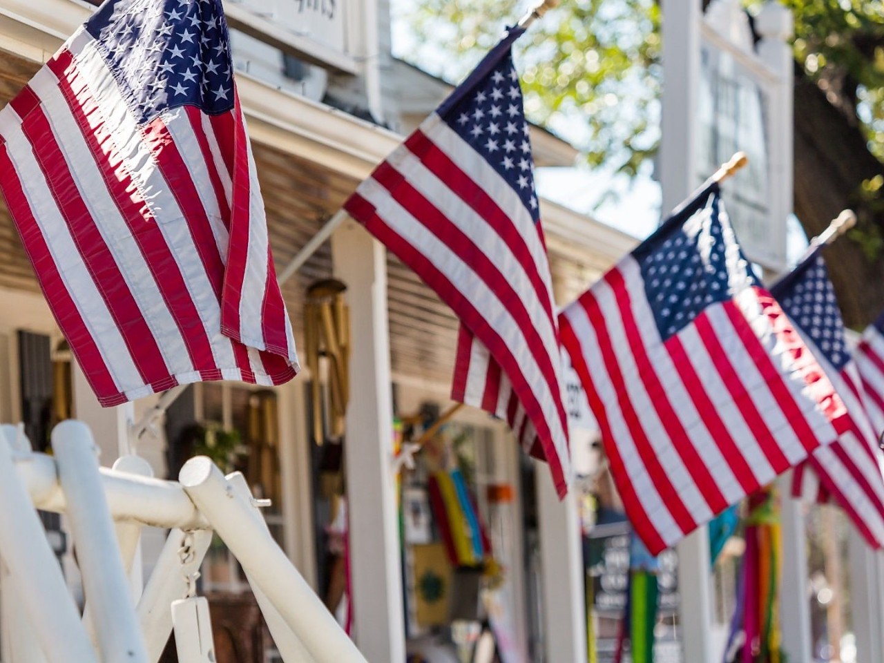American flags hang from the storefronts along a small-town main street