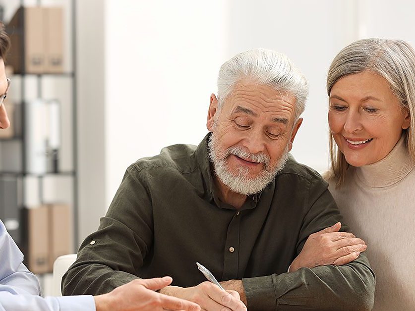 An advisor reviews documents with a couple