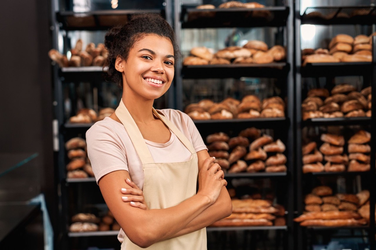 A smiling small-business owner standing in her bakery